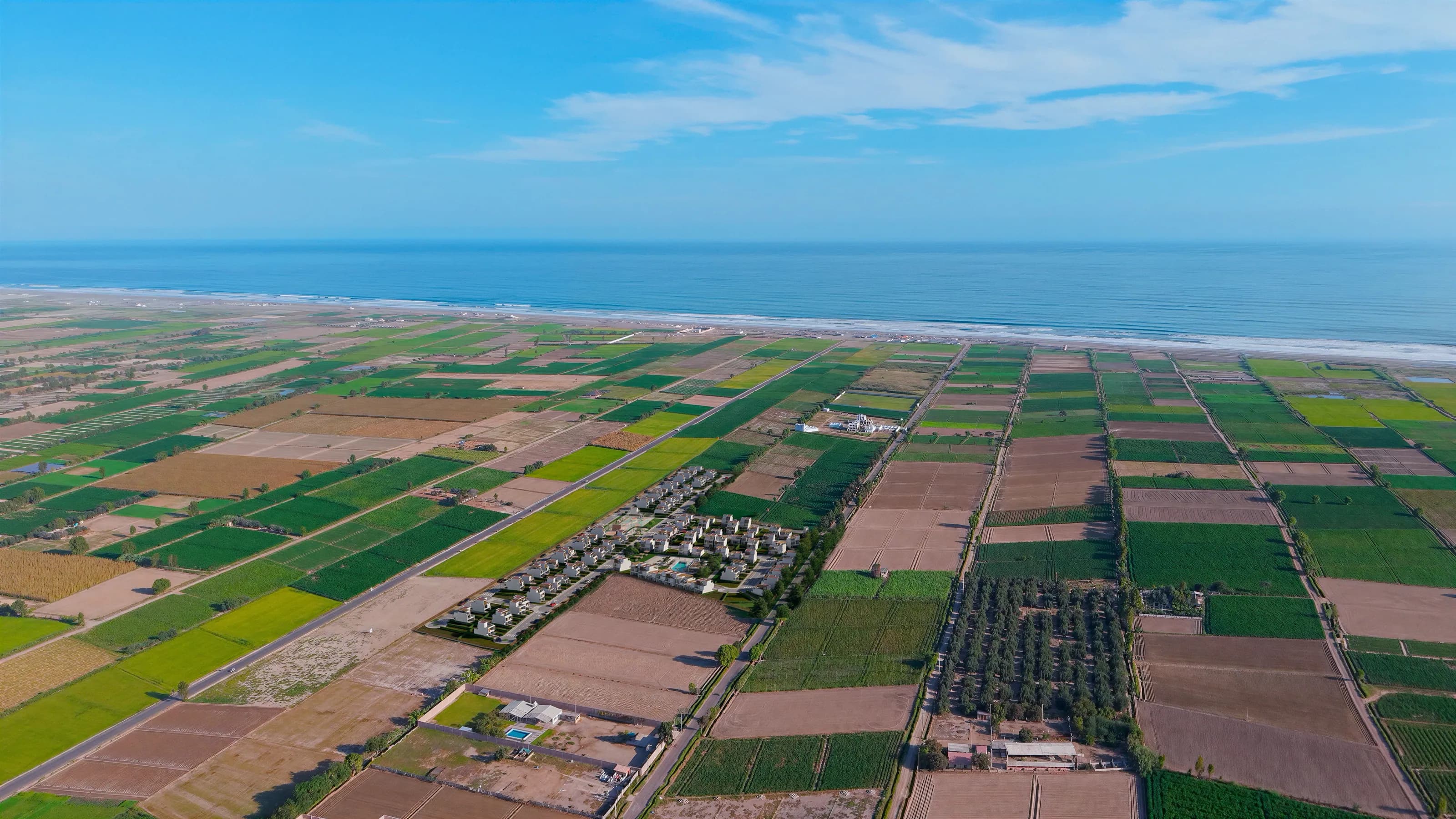 Fotomontaje aéreo de Residencial Aonami insertado en la campiña de Punta de Bombón con el mar al fondo